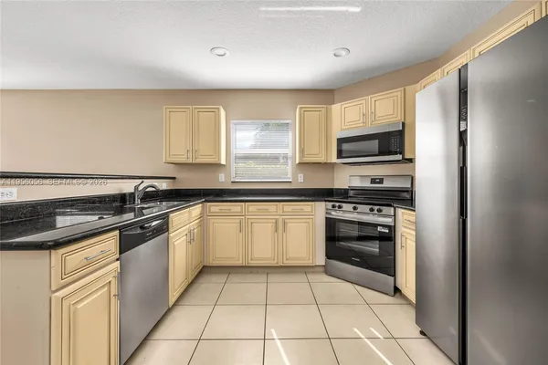 a kitchen with stainless steel appliances granite countertop a refrigerator and a stove top oven
