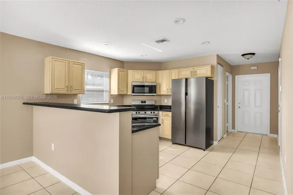 a kitchen with stainless steel appliances granite countertop a refrigerator and a stove top oven