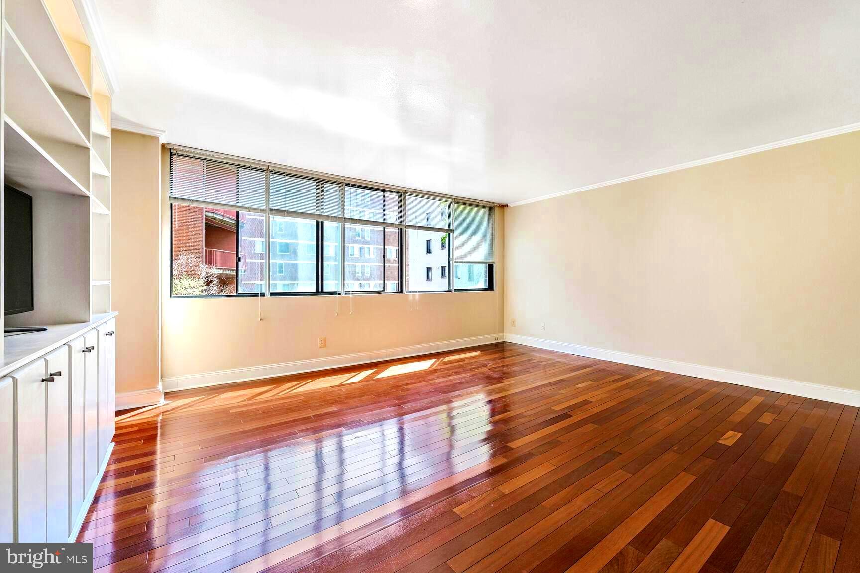 1245 13th Street Northwest, Unit 313 Washington, DC 20005 - Photo 14 of 43 a view of an empty room with wooden floor and a window