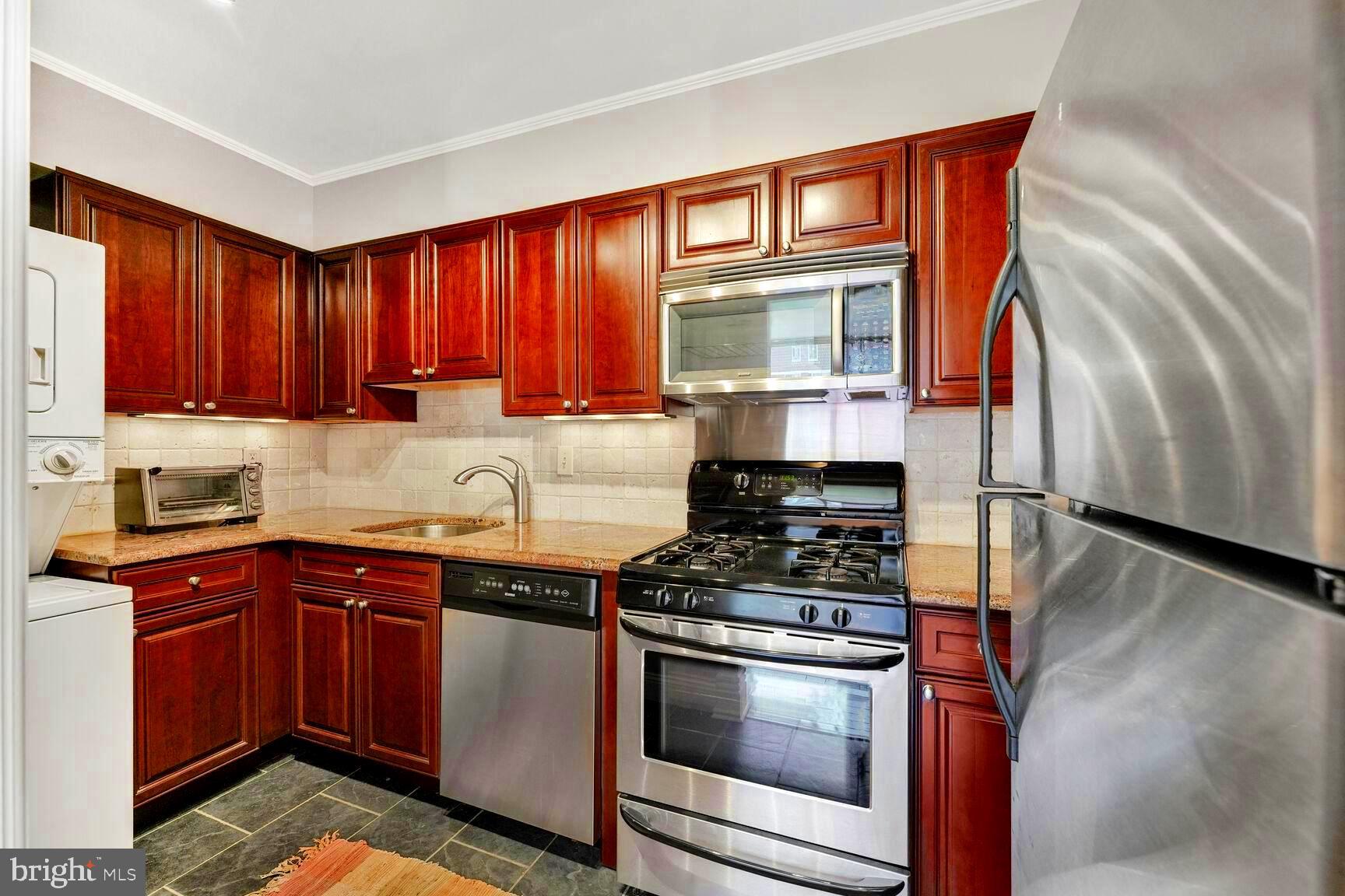 1245 13th Street Northwest, Unit 313 Washington, DC 20005 - Photo 7 of 33 a kitchen with stainless steel appliances granite countertop a stove a sink and a microwave