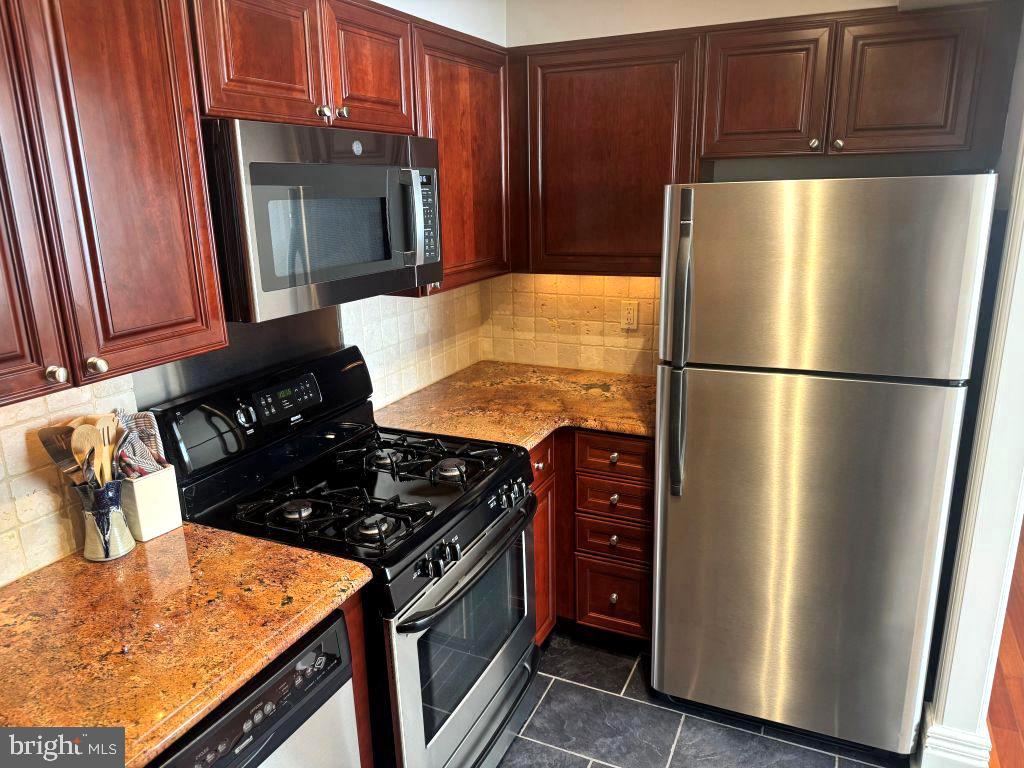 1245 13th Street Northwest, Unit 313 Washington, DC 20005 - Photo 7 of 43 a kitchen with stainless steel appliances granite countertop a refrigerator stove and sink