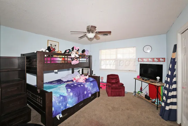 a bedroom with furniture and a flat screen tv