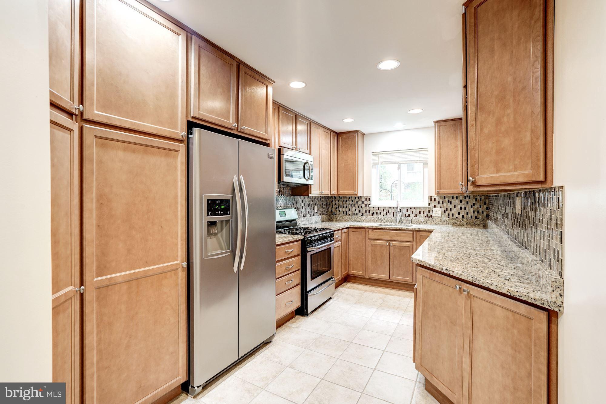 11089 Saffold Way Reston, VA 20190 - Photo 9 of 30 a kitchen with stainless steel appliances granite countertop a refrigerator and a sink