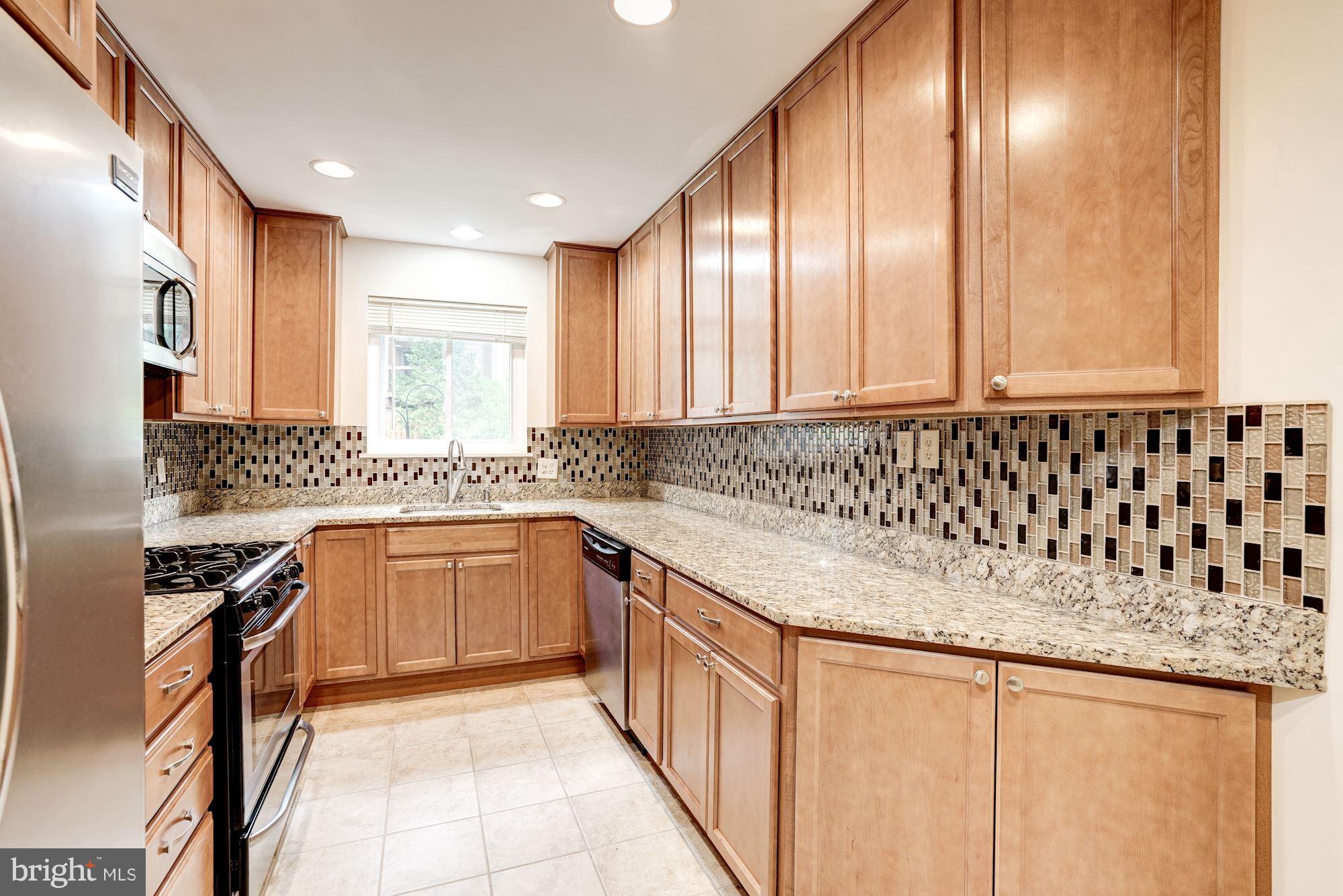 11089 Saffold Way Reston, VA 20190 - Photo 10 of 30 a kitchen with granite countertop a sink stove and cabinets