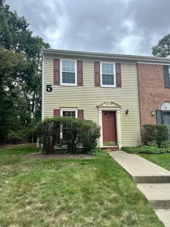 a front view of a house with a garden and yard