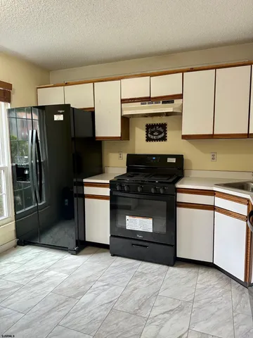a kitchen with granite countertop a refrigerator and a stove