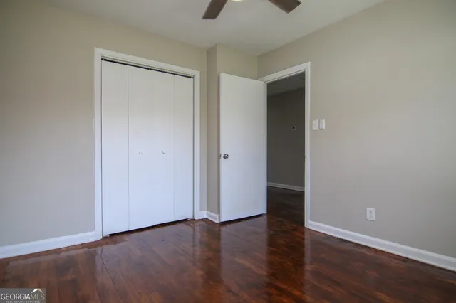 a view of an empty room with wooden floor