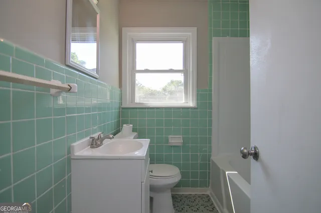 a bathroom with a toilet sink and mirror