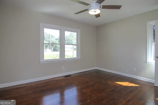 a view of a room with wooden floor and a window