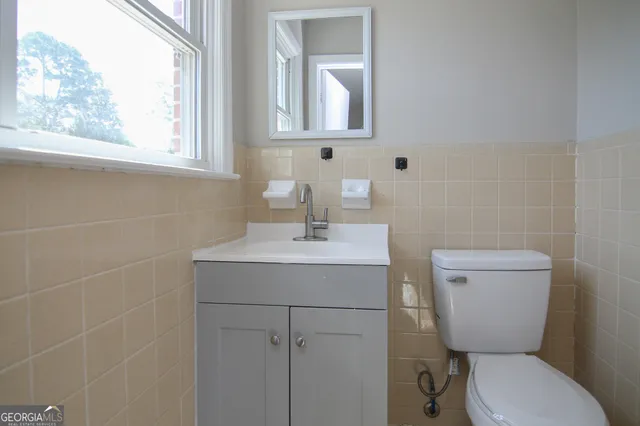 a bathroom with a toilet sink and mirror