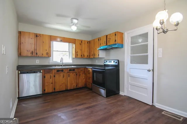 a kitchen with kitchen island granite countertop a sink cabinets and stainless steel appliances