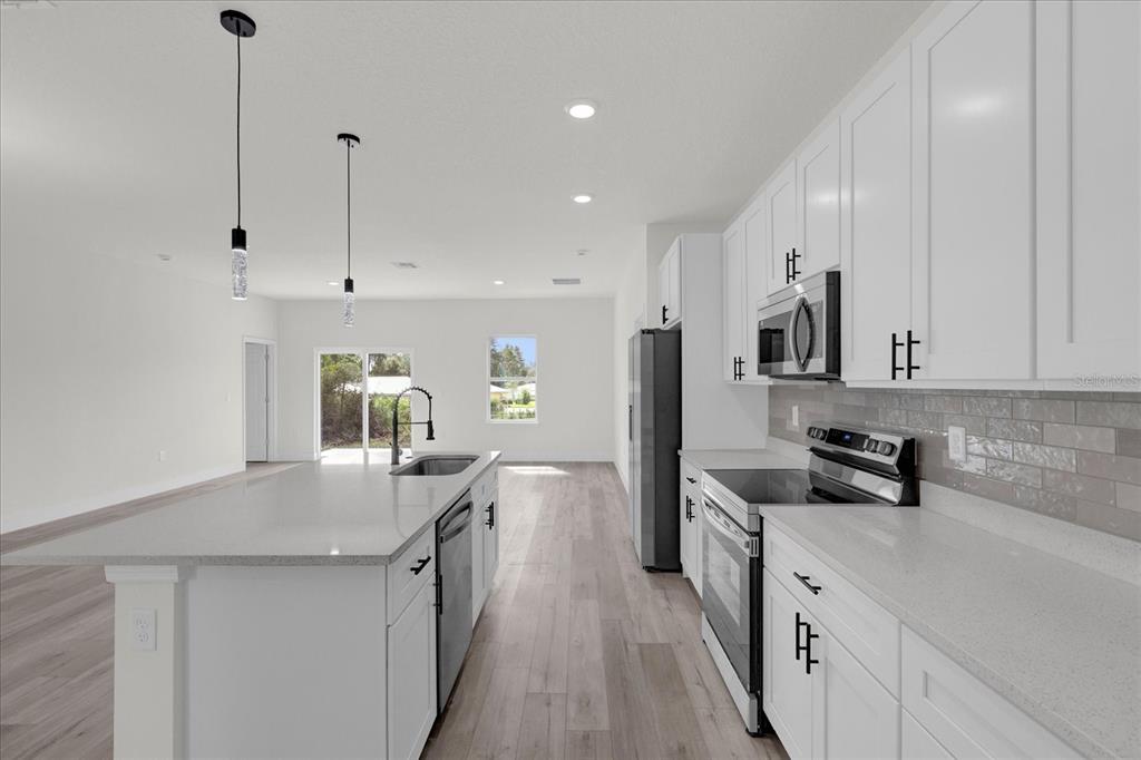 2396 Southwest 147th Lane Road Ocala, FL 34473 - Photo 6 of 32 a kitchen with stainless steel appliances granite countertop a sink a stove and a refrigerator