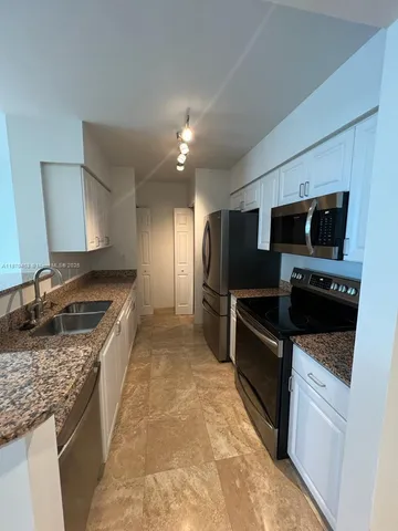 a large kitchen with a stove and a sink