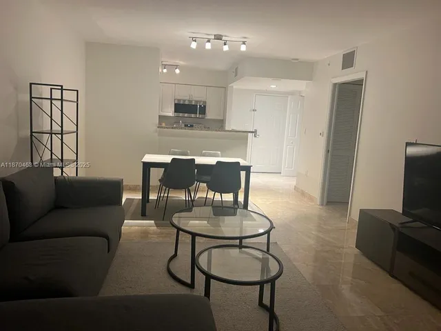 a living room with furniture a dining table and kitchen view