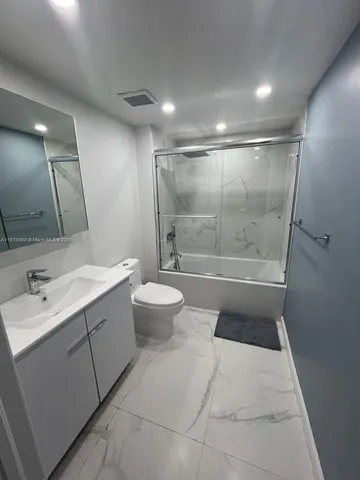 a bathroom with a bathtub shower sink and toilet