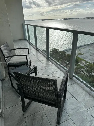 a view of a balcony with furniture and wooden floor