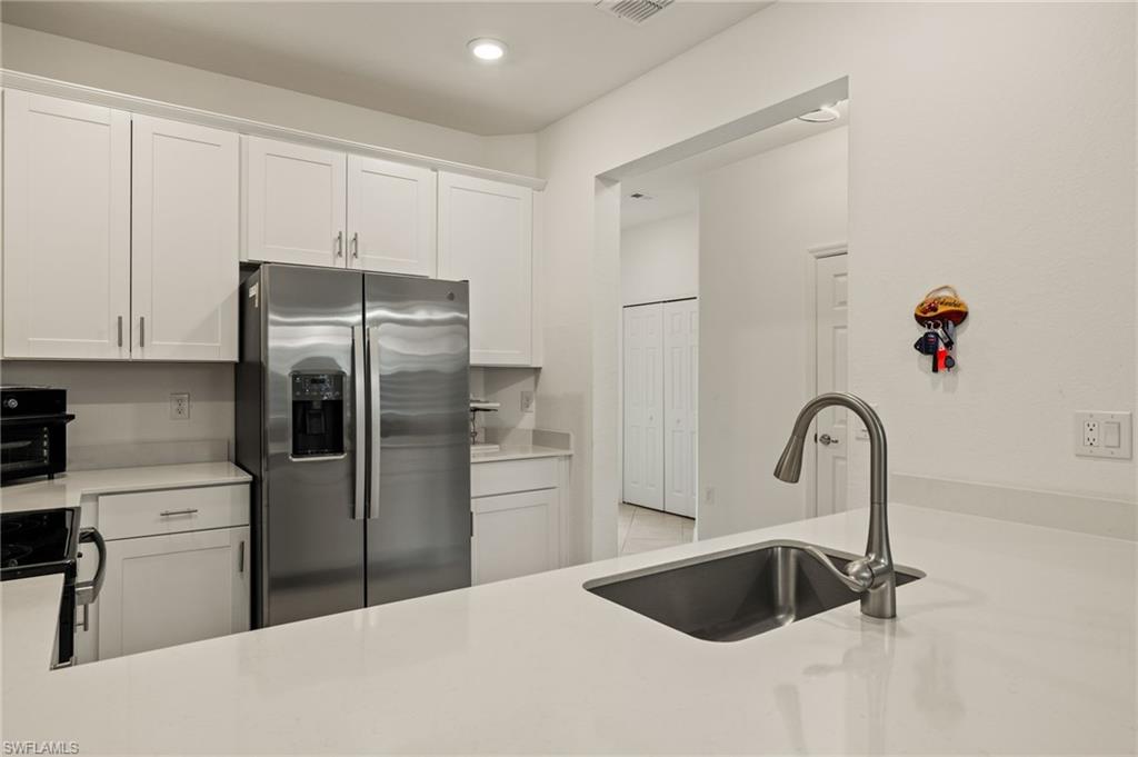 2934 Citrus Street Naples, FL 34120 - Photo 6 of 29 a kitchen with a refrigerator and cabinets