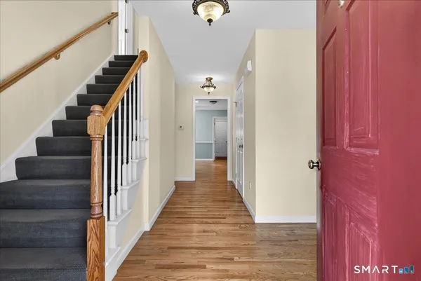 a view of a hallway with wooden floor and stairs