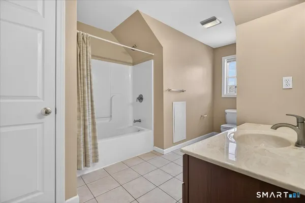 a bathroom with a granite countertop sink a mirror and a bathtub