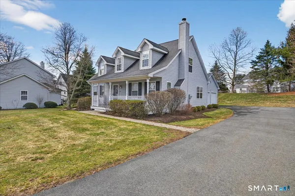 a front view of house with yard and trees in the background