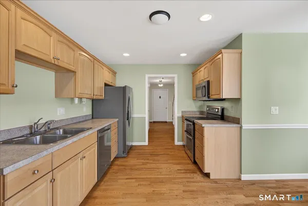 a kitchen with stainless steel appliances granite countertop a sink refrigerator and cabinets