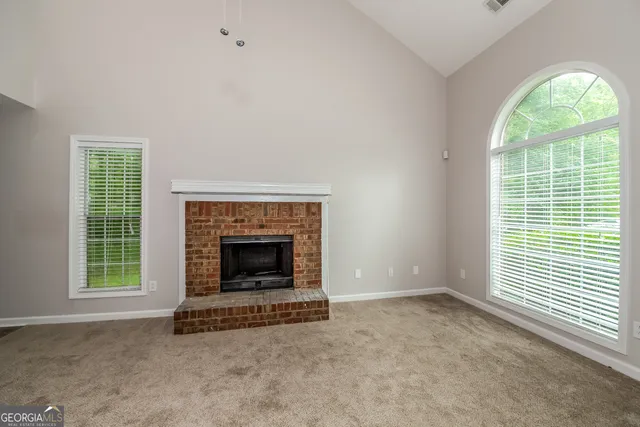 an empty room with fireplace and windows