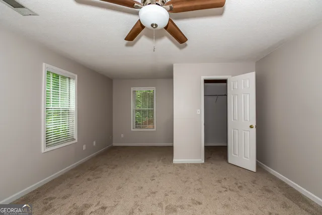 a view of room with chandelier fan and windows
