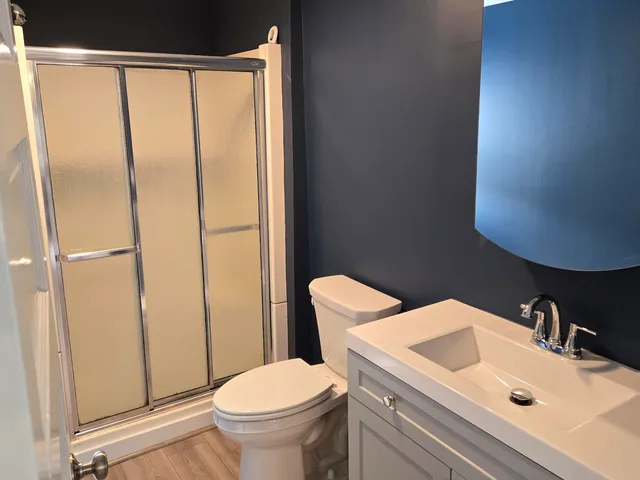 a bathroom with a sink a toilet and shower