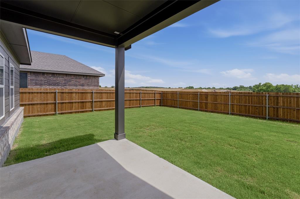 3504 Helena Street Gainesville, TX 76240 - Photo 14 of 19 Expansive backyard featuring a concrete patio, covered porch area, and a privacy fence