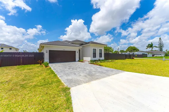 a view of yellow house with swimming pool and a yard
