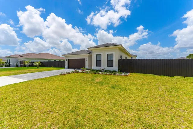 a front view of a house with yard and swimming pool