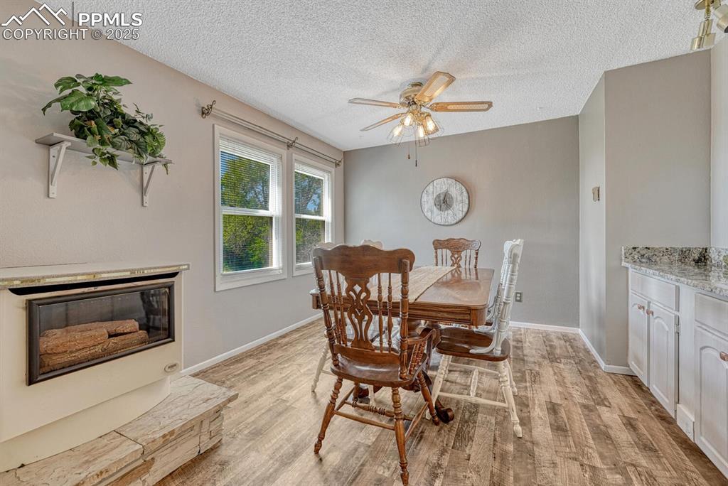 1661 Deer Creek Road Monument, CO 80132 - Photo 19 of 48 Dining room with gas stove and ceiling fan and LVP flooring
