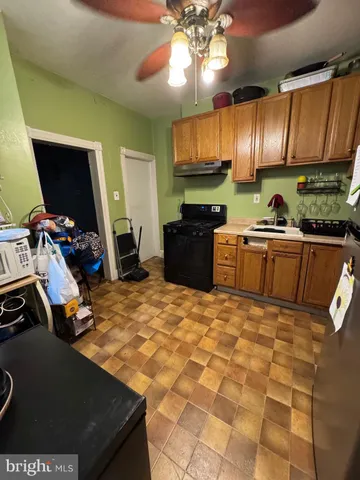 a kitchen with kitchen island granite countertop a sink appliances and cabinets