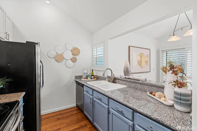 a bathroom with a granite countertop sink a mirror and shower