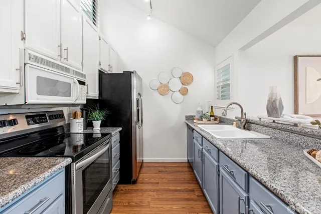 a kitchen with stainless steel appliances granite countertop a sink stove and refrigerator