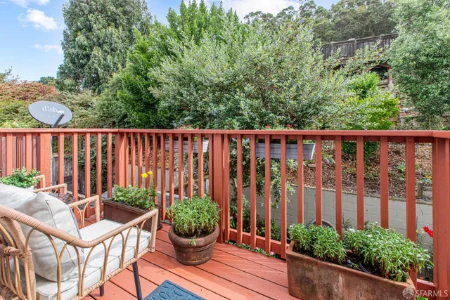 a balcony with chairs and with potted plants