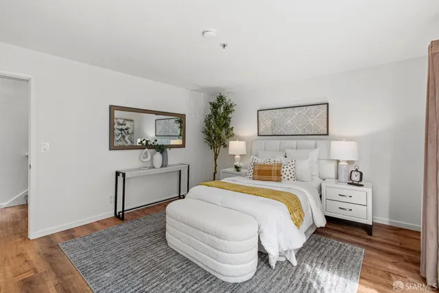 a bedroom with a large bed and a chandelier