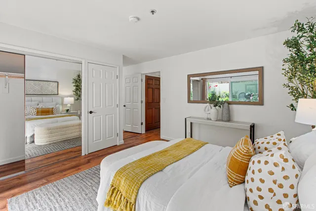 a bedroom with a bed and a large window with the outer view