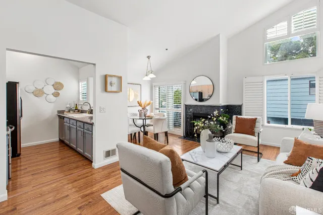 a living room with furniture a wooden floor and a large window