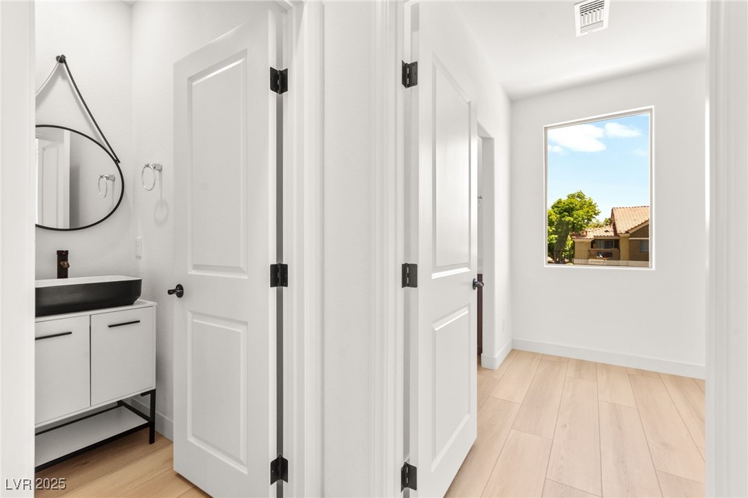 5606 Spring Trellis Street Las Vegas, NV 89113 - Photo 11 of 44 Corridor with light wood-style flooring and baseboards