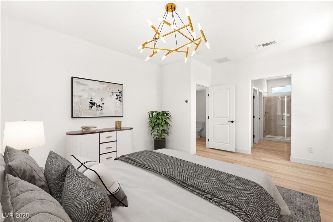 5606 Spring Trellis Street Las Vegas, NV 89113 - Photo 13 of 44 Bedroom featuring light wood-style floors and a chandelier