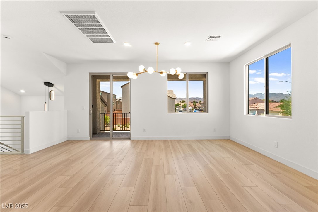 5606 Spring Trellis Street Las Vegas, NV 89113 - Photo 14 of 44 Empty room featuring plenty of natural light, a chandelier, light wood-style floors, and recessed lighting