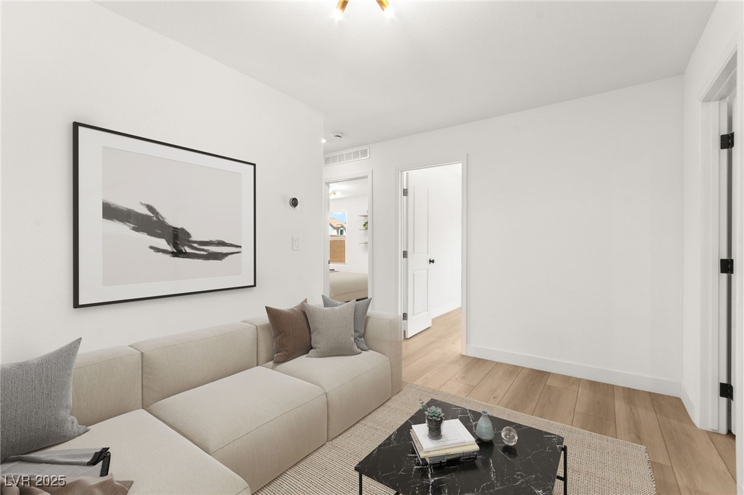 5606 Spring Trellis Street Las Vegas, NV 89113 - Photo 16 of 44 Living room featuring light wood-style flooring and baseboards