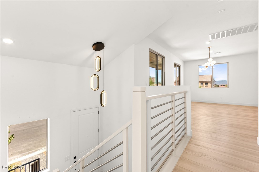 5606 Spring Trellis Street Las Vegas, NV 89113 - Photo 19 of 44 Corridor with an upstairs landing, recessed lighting, light wood-style flooring, and a chandelier