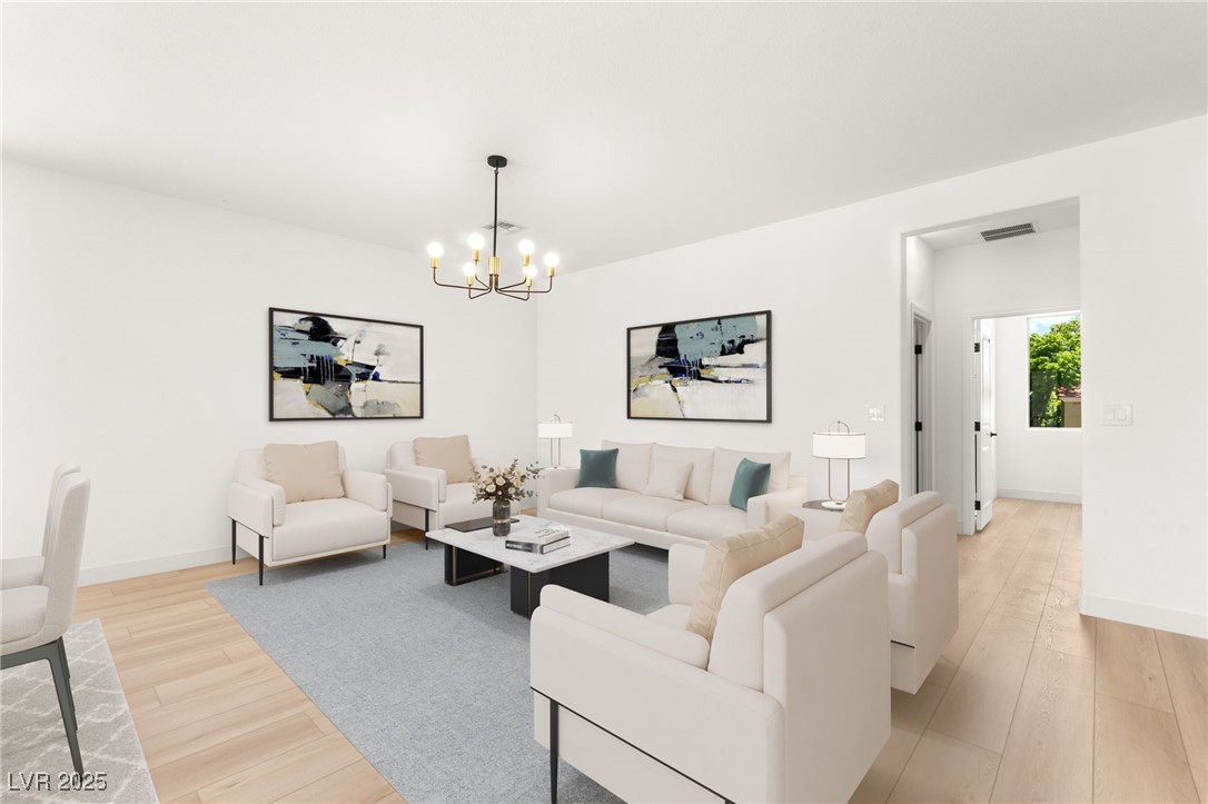 5606 Spring Trellis Street Las Vegas, NV 89113 - Photo 20 of 44 Living room featuring a chandelier and light wood-type flooring
