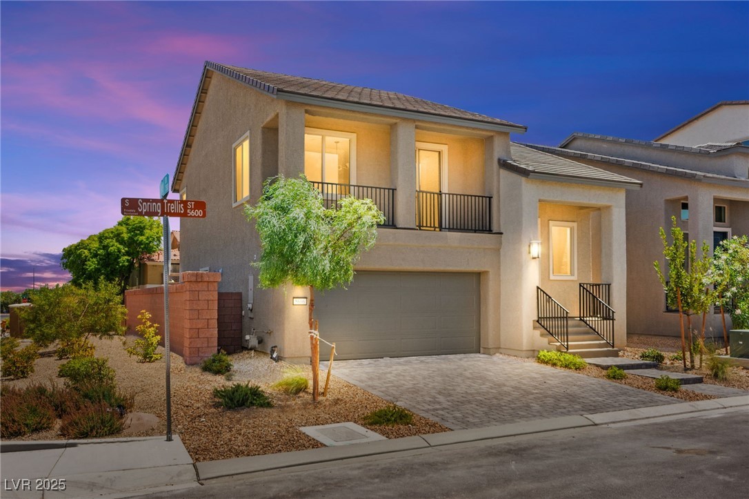 5606 Spring Trellis Street Las Vegas, NV 89113 - Photo 2 of 44 View of front facade with a balcony, stucco siding, driveway, and an attached garage