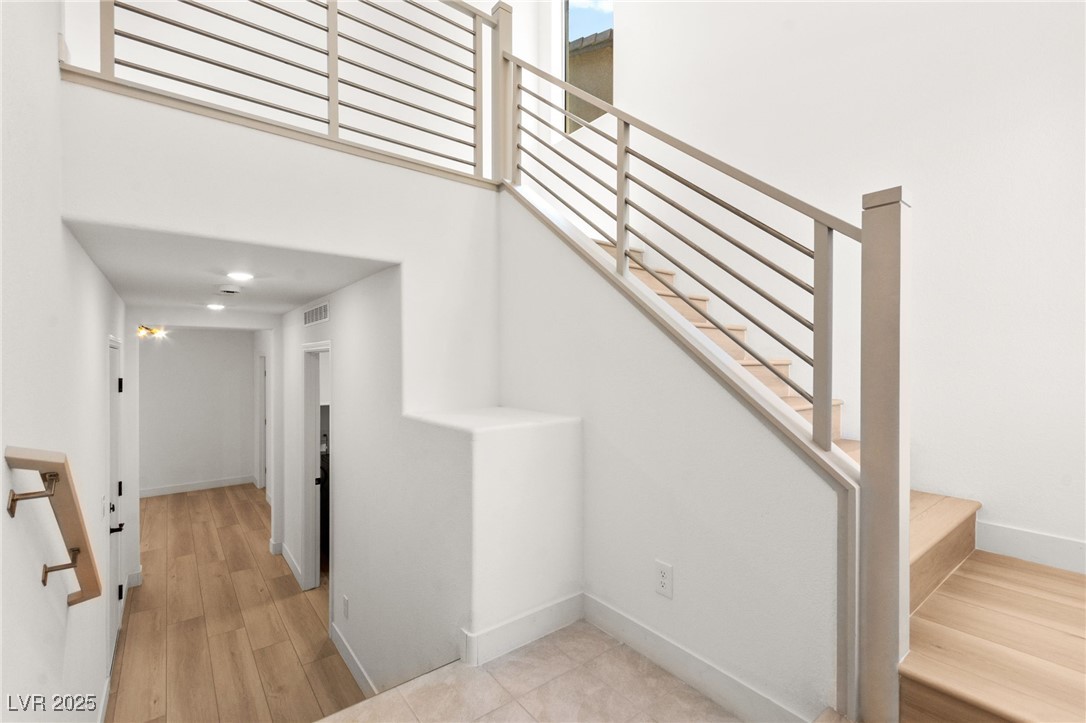 5606 Spring Trellis Street Las Vegas, NV 89113 - Photo 24 of 44 Stairway featuring wood finished floors and a towering ceiling