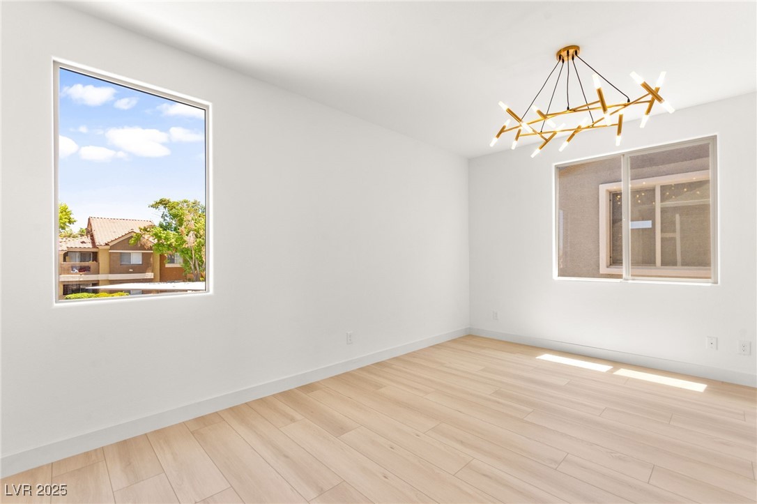 5606 Spring Trellis Street Las Vegas, NV 89113 - Photo 25 of 44 Spare room featuring a chandelier and wood finished floors
