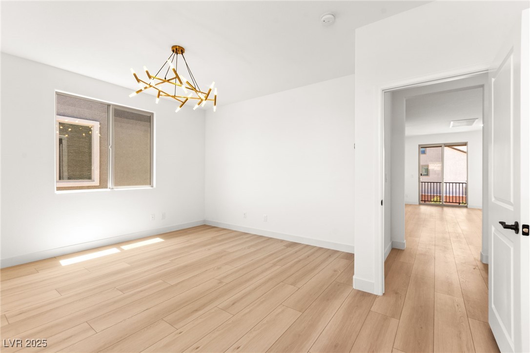 5606 Spring Trellis Street Las Vegas, NV 89113 - Photo 26 of 44 Spare room with a chandelier and light wood-style floors