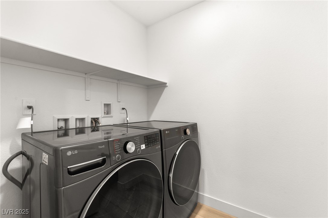 5606 Spring Trellis Street Las Vegas, NV 89113 - Photo 35 of 44 Washroom featuring washing machine and dryer and light wood-style flooring